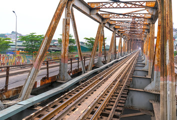 Vintage railroad tracks leading over the famous Long Bien Bridge, Hanoi, Vietnam. This is the railway line was built so long and still in operation today