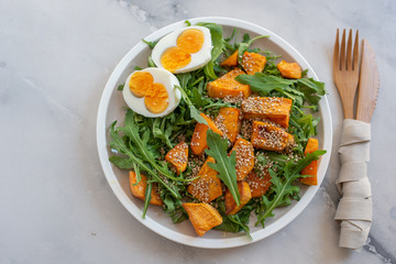 healthy salad with arugula, sweet potato and eggs