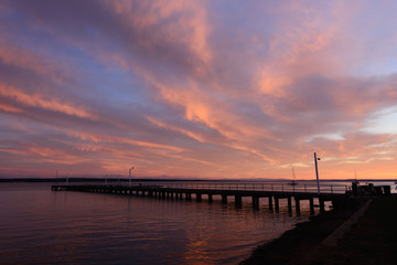 Corinella pier at sunrise viewed from the side