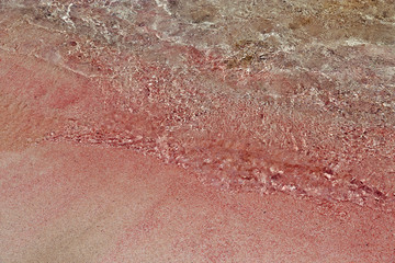 Fototapeta premium Famous pink sand beach Elafonisi. Popular place on the island of Crete in Greece. Beautiful sand of amazing color. Clear water in shallow water.