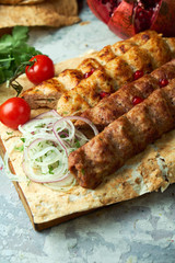 Plates of meat with barbecue and kebab, on gray background