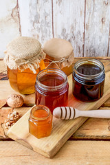 Honey in glass jar on wooden background
