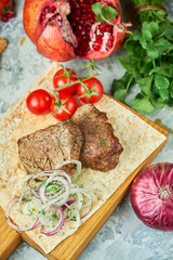 Wooden board with meat from a barbecue,
