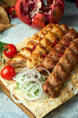 Plates of meat with barbecue and kebab, on gray background