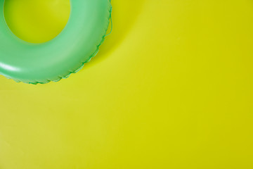 Green Inflatable Ring on yellow background