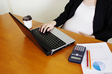 Pregnant woman working with labtop.