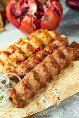 Plates of meat with barbecue and kebab, on gray background