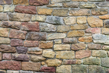 Obraz premium Stone texture. Colorful rock wall. Wall of colored stones bonded with cement.