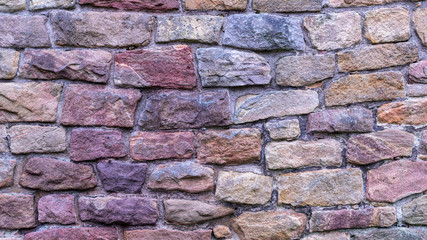 Stone texture. Colorful rock wall. Wall of colored stones bonded with cement.