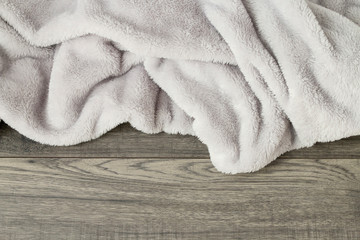 Fototapeta na wymiar Grey blanket on wooden background