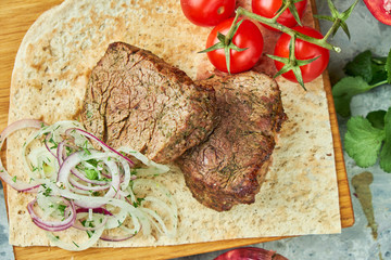 Wooden board with meat from a barbecue,