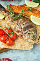 Grilled dorado fish and salmon steak on a wooden board 