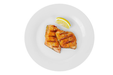 Fish, trout, keta, pink salmon, a pieces baked, fried over an open fire, with slice of lemon. Appetizing on white isolated background, view from above