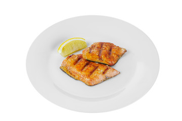 Fish, trout, keta, pink salmon, a piece, baked, fried over an open fire, with a slice of lemon. Appetizing on white isolated background side view