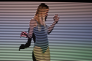 Beautiful girl blonde in lingerie dances in black and white stripes from the projector