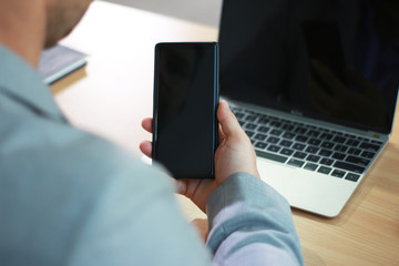 Mock up of a business man holding smartphone device