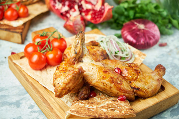 Grilled chicken on a wooden board with vegetables 