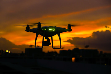 Naklejka na ściany i meble Drone flying over silhouette city sunset sky with cloud