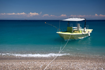 Obraz premium Boat in the bright beautiful transparent sea. Summer, sun, blue turquoise sea