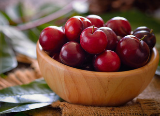 Mature fruits of plum house (Prunus domestica L.) on wooden background.