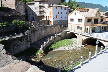 Fototapeta na wymiar An ancient bridge over a small river in a Spanish town.