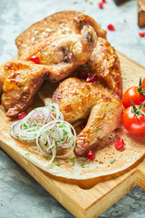 Grilled chicken on a wooden board with vegetables 