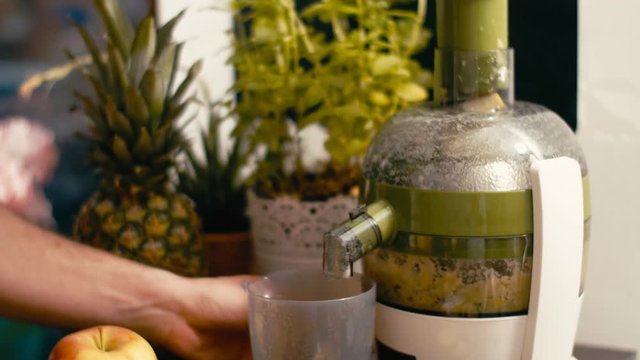 Hand using a blender or mixer to make vegan healthy juice