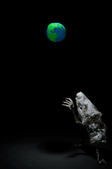 Plasticine Earth planet handmade above fantasy creature sculpture from plastic cups, forks and spoons, in selective light. Ecology Concept for Earth Hour, Earth Day, Ocean Day and other ECO dates.