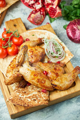 Grilled chicken on a wooden board with vegetables 