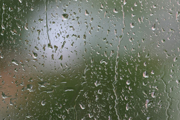 Raindrops on window glass during the rain close up. Natural background