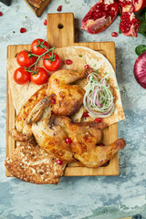 Grilled chicken on a wooden board with vegetables 