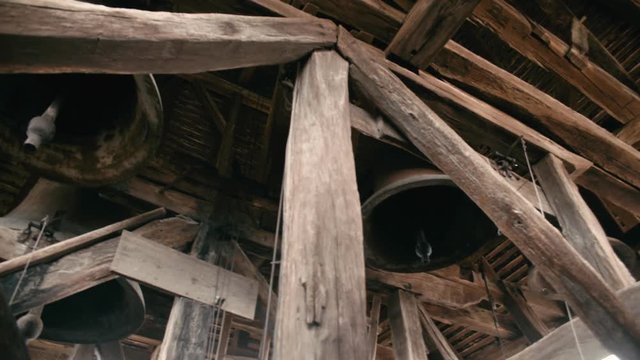 Bell tower from a medieval church with large bells and wooden logs