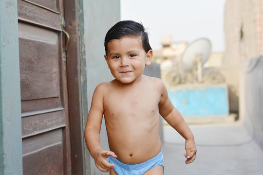 Sporty little latin boy smiles outside.