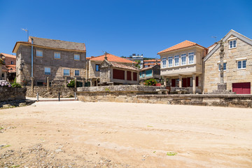 Combarro, Spain. Landscape of the old town with a traditional horreo barn and a stone cross