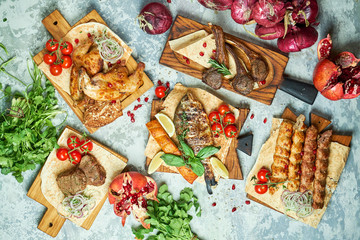Plates of meat with barbecue and kebab, top view on gray background