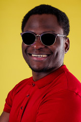 Obraz premium handsome happy young african man Kenya Africa tourist isolated yellow wall background holding tickets with passport and coctail glass trip around the world