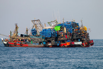 Large industrial fishing trawlers operating together in a tropical ocean