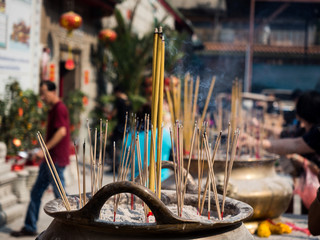 Incense sticks on joss stick pot burning and smoke used to pay respect to Buddha.