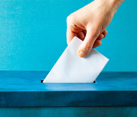 european Union parliament election concept - hand putting ballot in blue election box