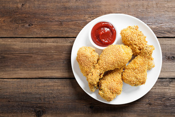 Crispy  fried chicken drumsticks  in a wooden table.