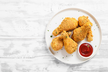 Crispy  fried chicken drumsticks  in a wooden table.