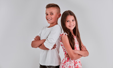 Cute girl and boy on a gray background