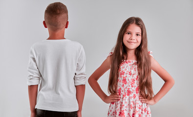 Cute girl and boy on a gray background