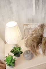 Home interior. Farmhouse design elements. A beautiful nightstand with rununculus and dry flowers. Atmosphere of comfort