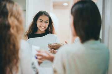Mom and teenage daughter face wash cleansing with foam in bathroom every day at morning before go to work and study.