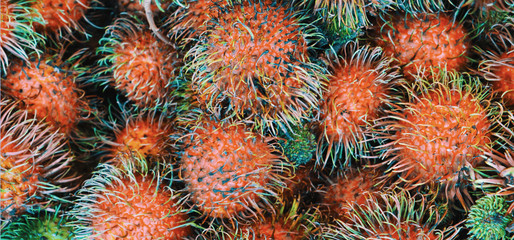 Fototapeta premium A large number of rambutans as a background. Unusual tropical fruits.
