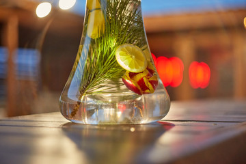 Modern Hookah for tobacco smoking made of metal, glass and plastic on wooden table.The background-summer sunny garden. Selective focus.