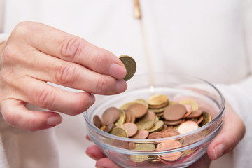 woman's hands holding jar of coins and entering a, savings concept