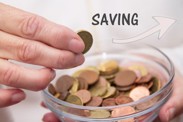 woman's hands holding jar of coins and entering a, savings concept