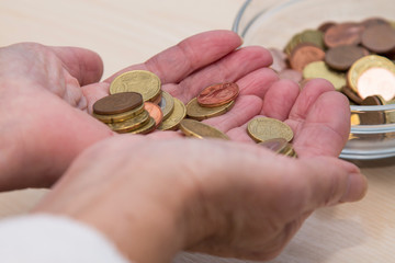 hands with coins and jar of coins, retirement concept